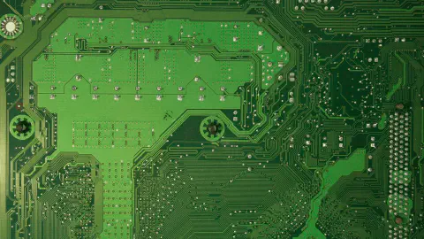 close-up detalhado de uma placa de circuito impresso (PCB) de cor verde. A superfície é coberta por uma com