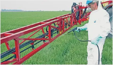 agricultor profissionalmente equipado em meio a uma lavoura verdejante. O trabalhador veste um traje de p