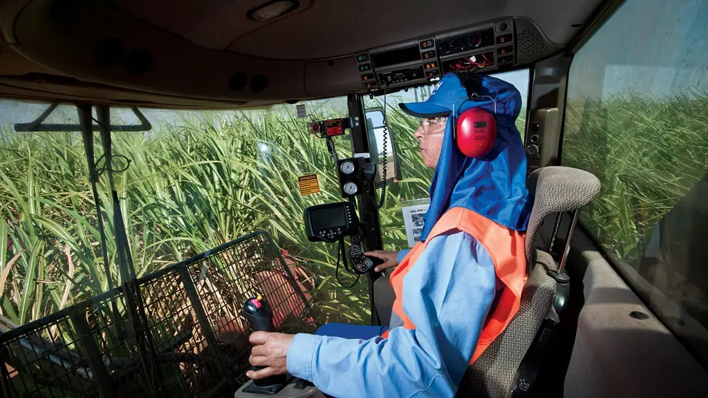 perspectiva interna da cabine de uma moderna colheitadeira agrícola, com um operador focado em seu trabalh