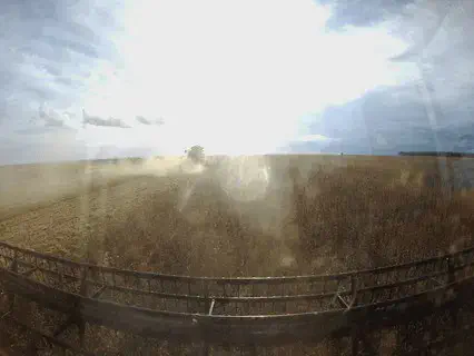 A imagem, em formato de GIF, captura a perspectiva em primeira pessoa de dentro da cabine de uma máquina agrícola, provavelme