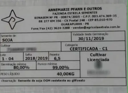 close-up da etiqueta de uma saca de sementes de soja. A etiqueta, de fundo branco com texto em preto e deta