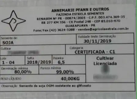 close-up da etiqueta de uma saca de sementes de soja. A etiqueta, de fundo branco com texto em preto e deta