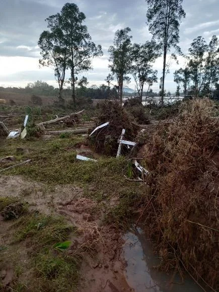 Desastres Climáticos no Campo: Prejuízos e Recuperação cenário de devastação em uma área rural, provavelmente após a ocorrência de um desastre natural como uma