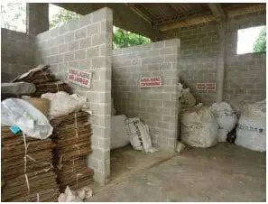 uma área de armazenamento e separação de resíduos em uma propriedade rural, construída com blocos de concreto