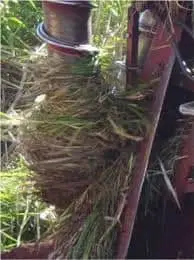 close-up de uma parte de um maquinário agrícola, possivelmente uma colheitadeira ou enfardadeira, com sua e