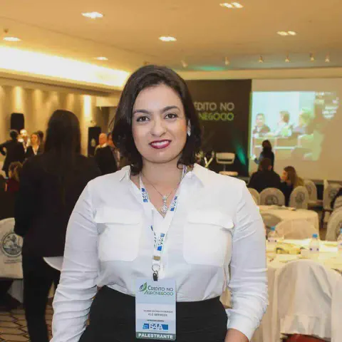 mulher em um ambiente de evento corporativo, provavelmente uma conferência ou seminário focado no agrone