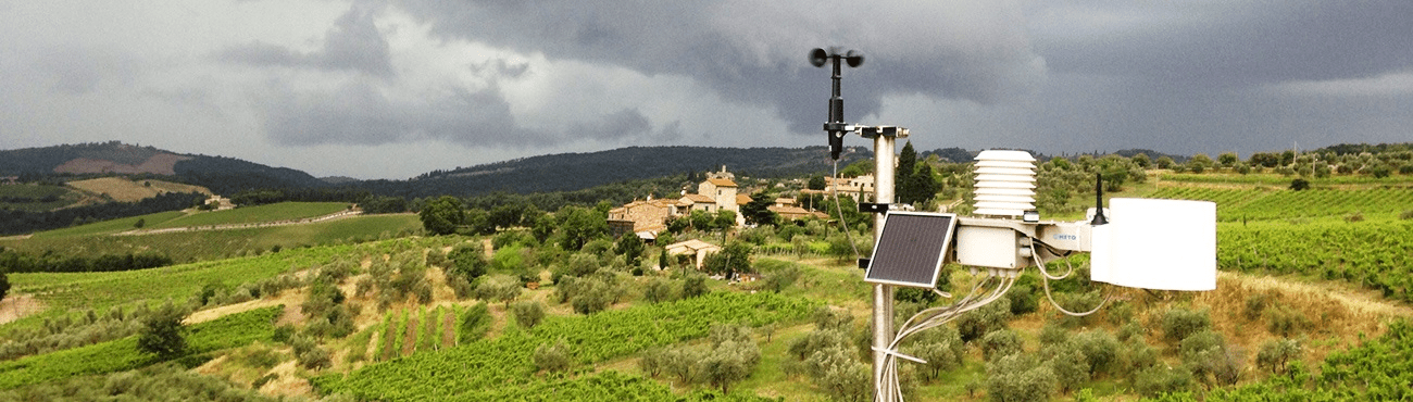 Estação Meteorológica na Lavoura: Agricultura de Precisão uma estação meteorológica moderna instalada em primeiro plano, contrastando com uma paisagem rural europeia ao