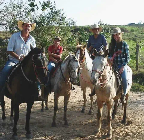 momento de lazer e união de um grupo de quatro pessoas, possivelmente uma família, em um ambiente rural.