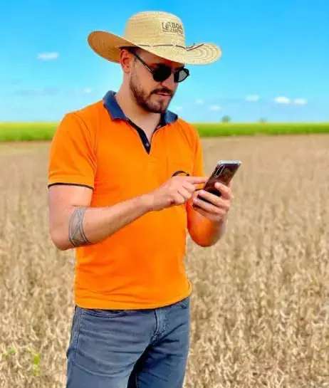 O produtor rural Nino Mosena em pé no meio de uma lavoura de grãos.