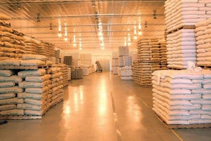 o interior de um amplo e bem iluminado armazém agrícola, meticulosamente organizado. Corredores extensos separ