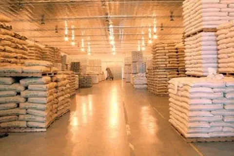 o interior de um amplo e bem iluminado armazém agrícola, meticulosamente organizado. Corredores extensos separ