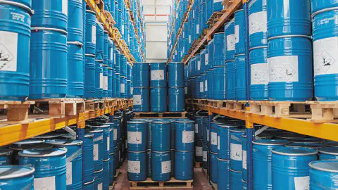 grande depósito industrial, meticulosamente organizado com altas prateleiras de estocagem. Inúmeros barris