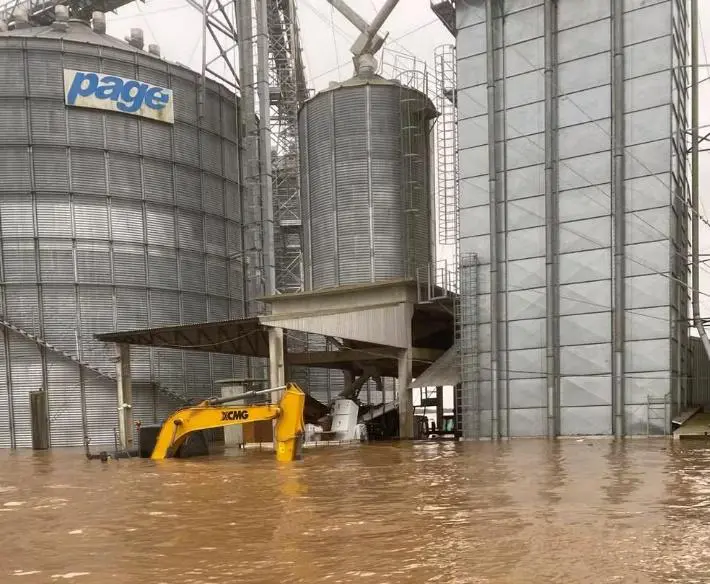 cenário de desastre em uma instalação de armazenamento de grãos, severamente afetada por uma inundação. G