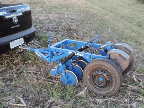 implemento agrícola de cor azul, especificamente uma plantadeira ou semeadora, da marca Falker, engatado na