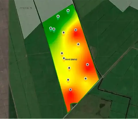 uma visualização de mapa de calor sobreposto a uma imagem de satélite de uma área agrícola, identificada como