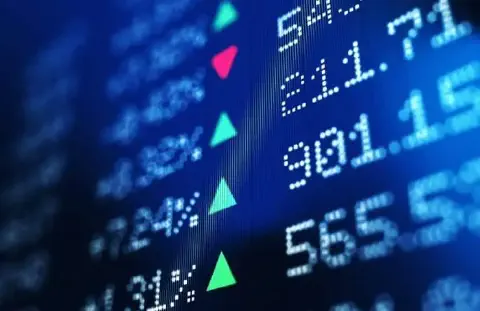 close-up de uma tela digital com dados do mercado financeiro, apresentada em um ângulo dinâmico. O fundo é