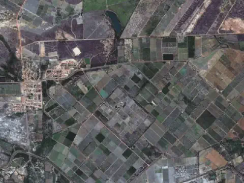 uma vista aérea de satélite de uma extensa área agrícola, caracterizada por um mosaico de talhões de diferente