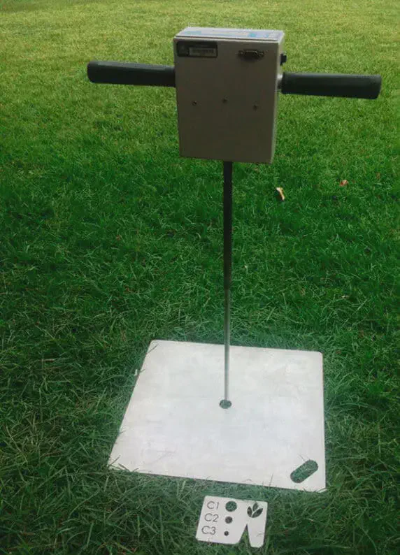 Penetrômetro para Análise de Compactação do Solo na Fazenda equipamento técnico para análise de solo, posicionado sobre um gramado verde. O aparelho, provavelmente um