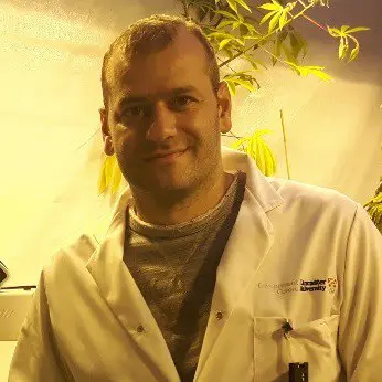 retrato de um homem de meia-idade, caucasiano, com cabelo curto e castanho, olhando diretamente para a câm