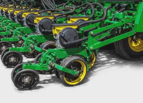 close-up detalhado de uma plantadeira agrícola de grande porte, provavelmente da marca John Deere, evidenci
