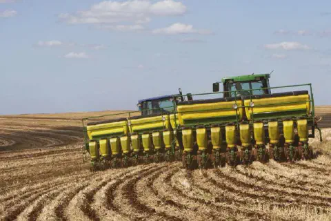 operação de plantio em larga escala em uma fazenda. Em primeiro plano, vemos dois tratores de grande por