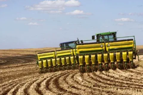 operação de plantio em larga escala em uma fazenda. Em primeiro plano, vemos dois tratores de grande por