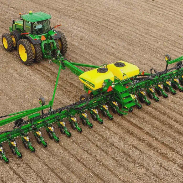 Plantio Mecanizado com Trator e Plantadeira de Precisão uma visão aérea de um trator John Deere, de cor verde e amarela, operando em um campo agrícola. O trator, equi