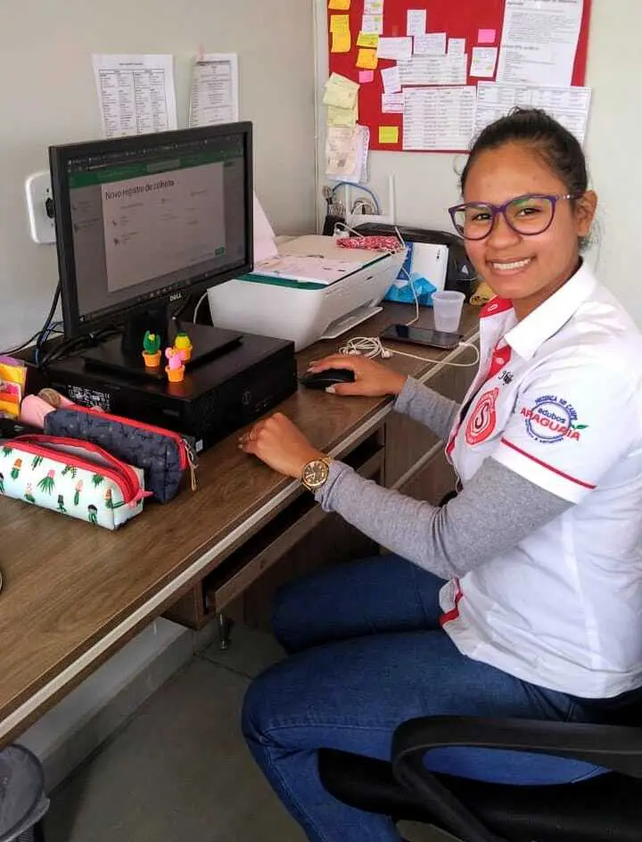 mulher jovem, possivelmente uma administradora ou agrônoma, em seu ambiente de trabalho, que parece ser