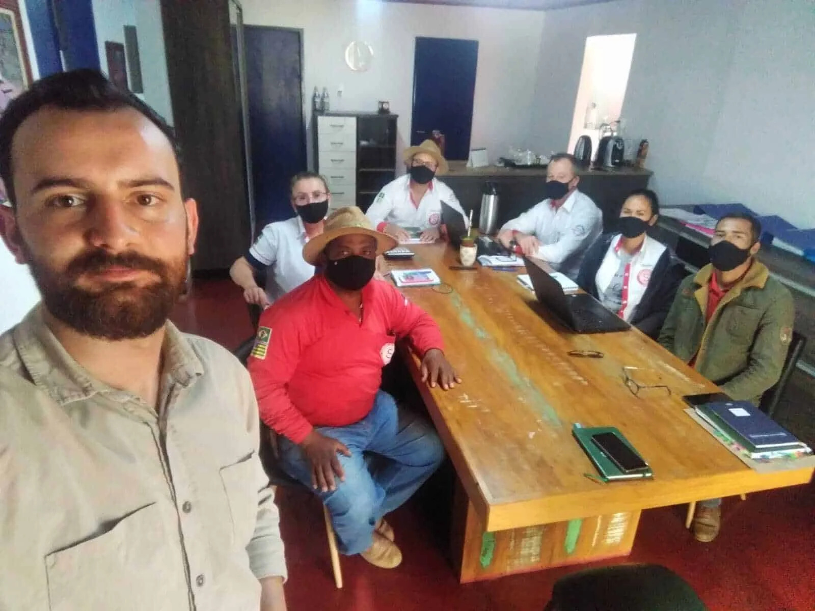 selfie tirada em um ambiente interno, provavelmente um escritório ou sala de reuniões, mostrando um grupo de t