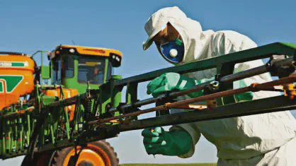 operador agrícola profissional realizando a manutenção ou ajuste de um pulverizador autopropelido de gran