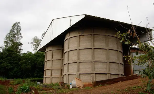 uma estrutura robusta de armazenamento agrícola, composta por dois grandes silos cilíndricos de concreto. As p