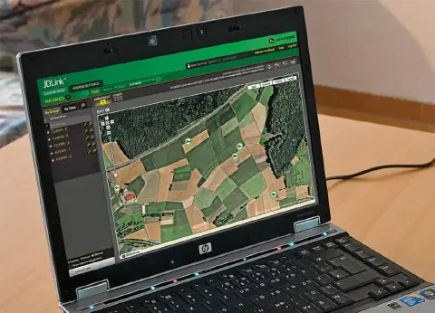 laptop HP aberto sobre uma mesa de madeira, com a tela mostrando a interface do software de telemetria agrí