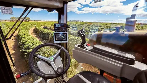 visão em primeira pessoa de dentro da cabine de uma máquina agrícola de alta tecnologia, possivelmente uma