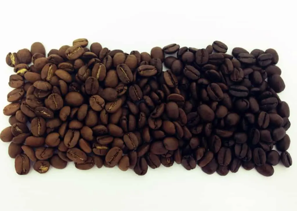 uma comparação visual direta entre dois níveis distintos de torra de grãos de café, dispostos lado a lado sobr