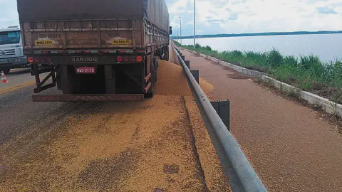 problema logístico comum no agronegócio: a perda de grãos durante o transporte. Vemos a traseira de um ca
