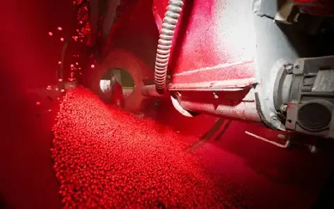 close-up do interior de uma máquina industrial durante o processo de tratamento de sementes. Milhares de pe