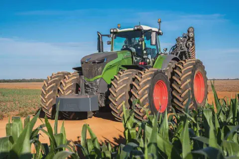 trator agrícola moderno e de grande porte, da marca Fendt, de cor verde vibrante, posicionado em uma estrad