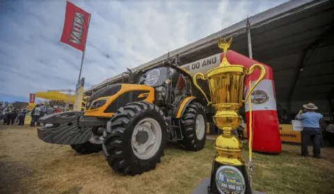 trator da marca Valtra, de cor amarela e preta, em destaque durante um evento, provavelmente uma feira agrí