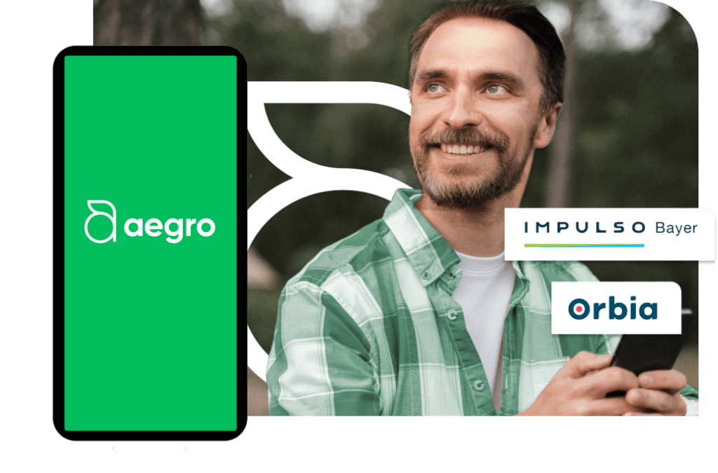 Imagem ilustrativa sobre programa de pontos. Homem segurando celular em ambiente rural, com camisa verde xadrez. Logotipos do Aegro, Impulso Bayer e Orbia na tela do celular.