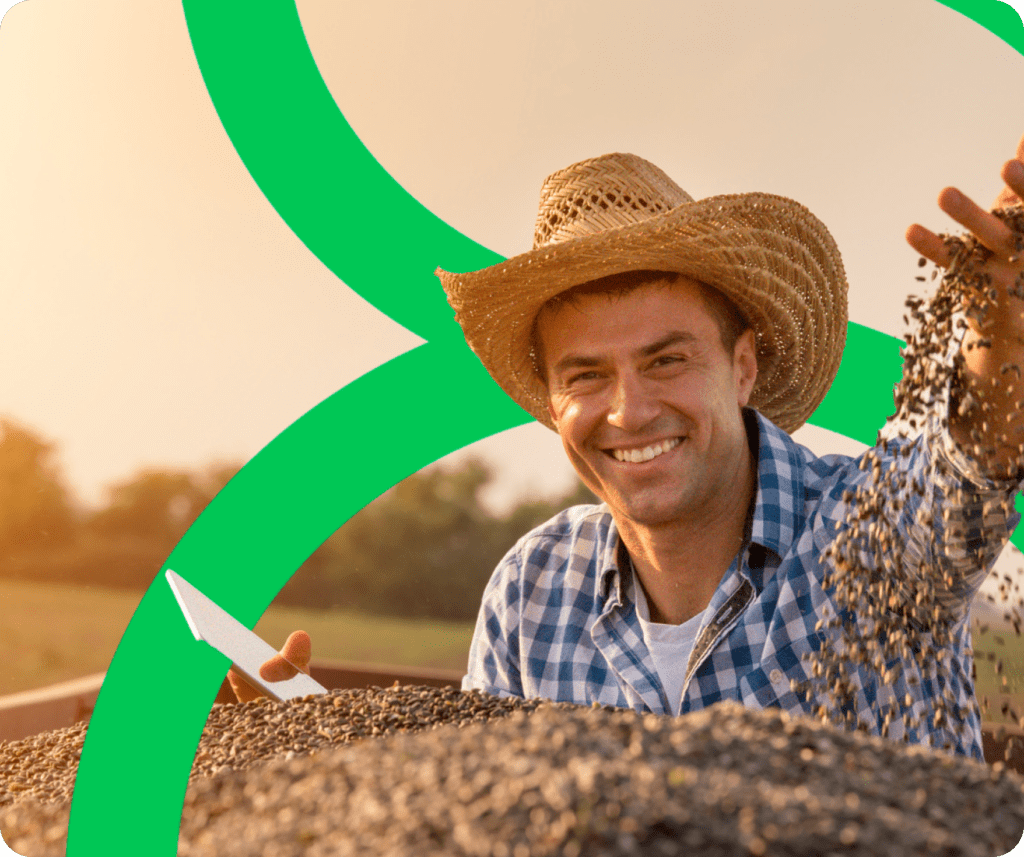 Agricultor segurando um celular em sua safra, usando chapéu de palha e camisa quadriculada, com símbolo da Aegro ao fundo.